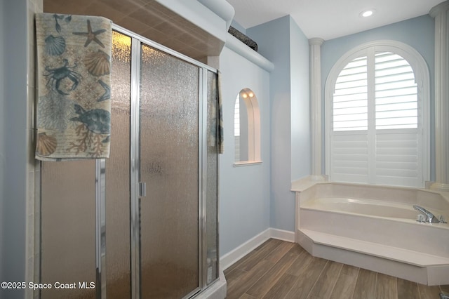 bathroom featuring wood-type flooring, shower with separate bathtub, and ornate columns