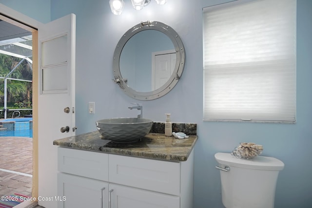 bathroom featuring a healthy amount of sunlight, toilet, and vanity