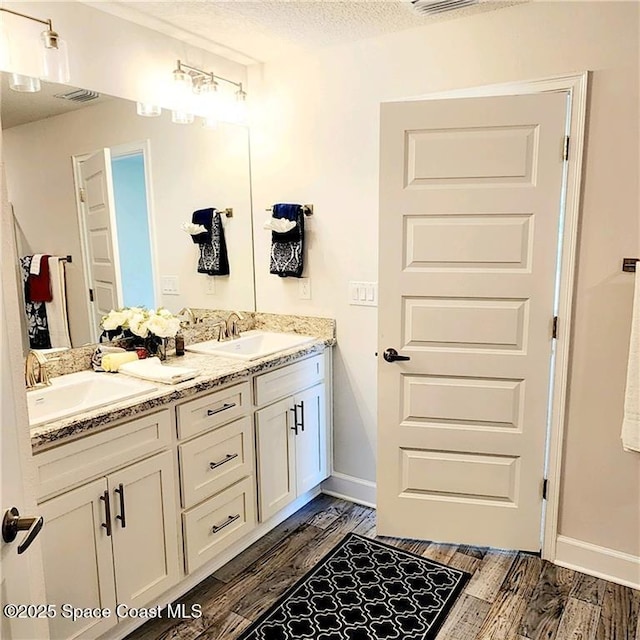 bathroom featuring wood-type flooring, a textured ceiling, and vanity