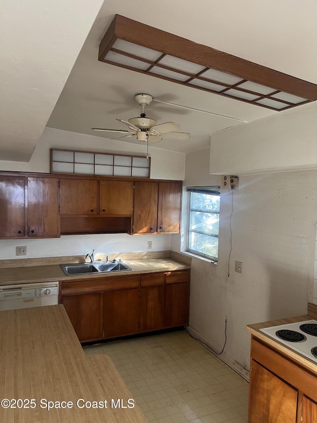 kitchen featuring white appliances, a sink, a ceiling fan, brown cabinets, and light floors