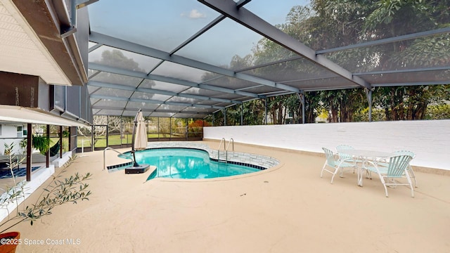 view of swimming pool featuring a patio and a lanai