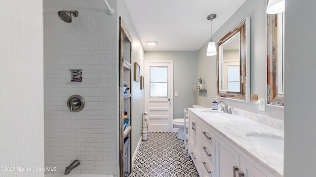 full bathroom featuring vanity, tiled shower / bath, and toilet