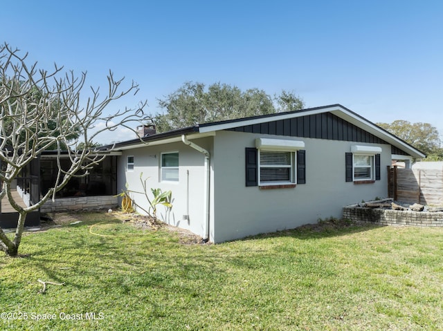 view of side of home with a yard