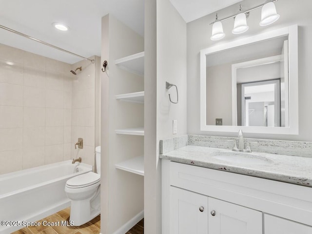 full bathroom with hardwood / wood-style flooring, toilet, vanity, and tiled shower / bath