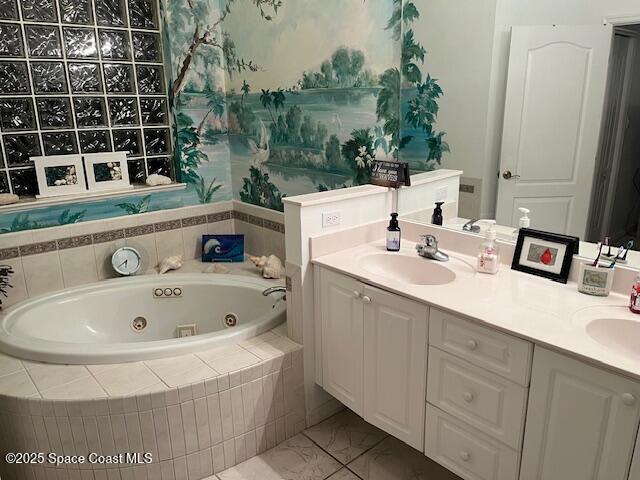 bathroom featuring tile patterned floors, vanity, and tiled bath