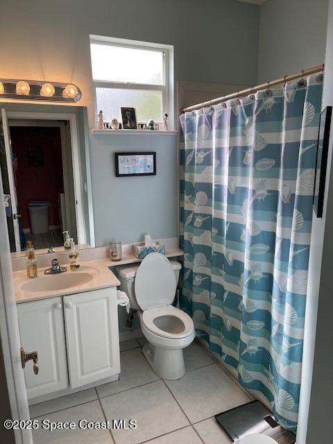 bathroom with tile patterned flooring, vanity, and walk in shower