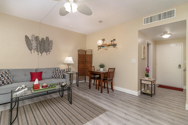 living room featuring ceiling fan and light hardwood / wood-style flooring