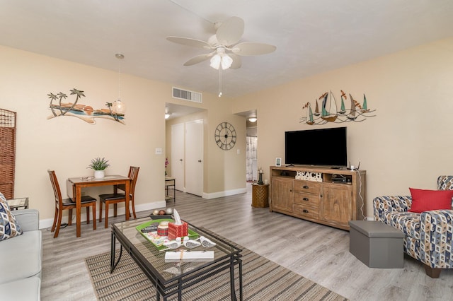 living room featuring ceiling fan and light hardwood / wood-style floors