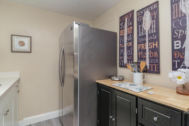 kitchen featuring hardwood / wood-style floors, stainless steel fridge, and wooden counters