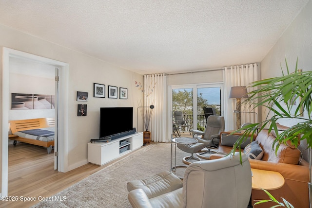 living room featuring a textured ceiling and light hardwood / wood-style floors