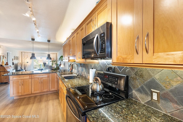 kitchen featuring decorative light fixtures, backsplash, kitchen peninsula, sink, and stainless steel range with electric stovetop