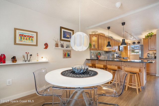 dining room with wood-type flooring, sink, and a textured ceiling