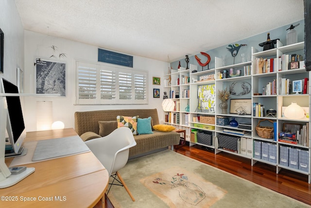 living area featuring a textured ceiling and hardwood / wood-style floors