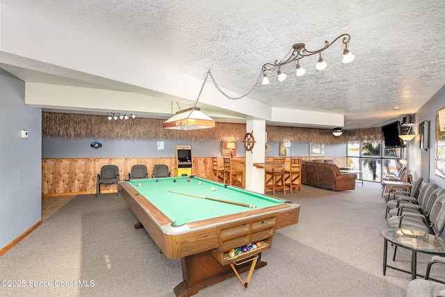 playroom featuring a textured ceiling, pool table, carpet, and wood walls