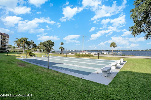 view of community with a water view and a lawn