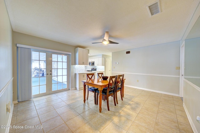 dining room featuring ceiling fan, light tile patterned floors, a textured ceiling, and french doors