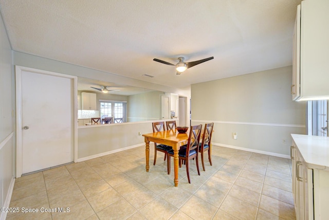 dining area with light tile patterned floors, a textured ceiling, and ceiling fan