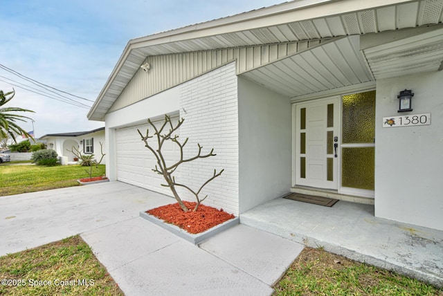 property entrance with a garage and a lawn