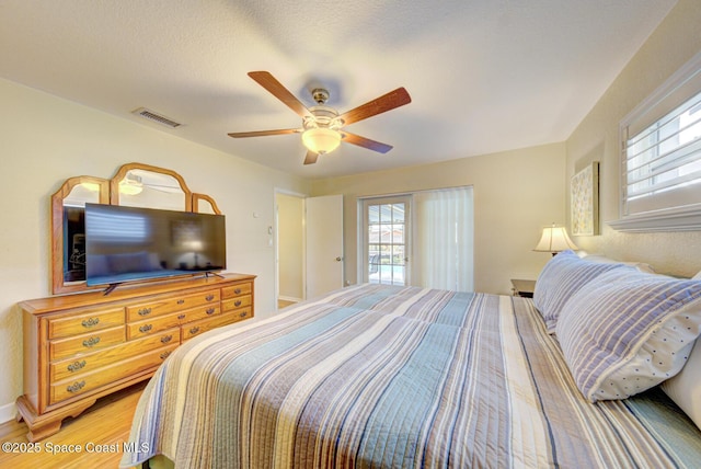 bedroom featuring hardwood / wood-style flooring, a textured ceiling, and ceiling fan