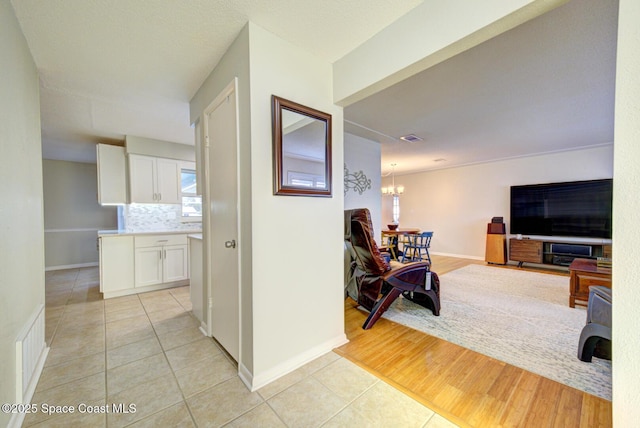 hall featuring an inviting chandelier and light tile patterned floors