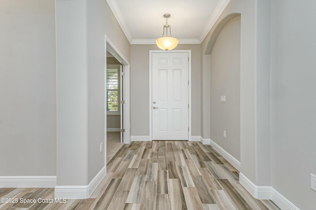 foyer featuring ornamental molding and light wood-type flooring