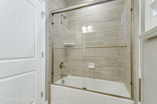 bathroom with bath / shower combo with glass door