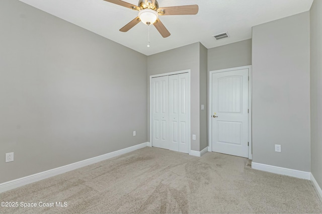 unfurnished bedroom with light carpet, ceiling fan, and a closet