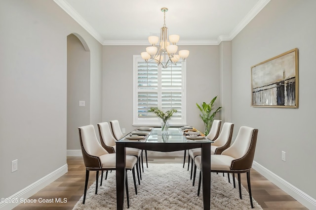 dining space with an inviting chandelier, hardwood / wood-style floors, and ornamental molding