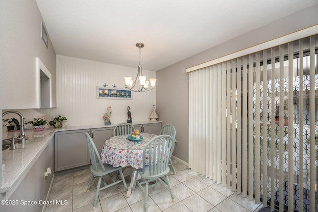 dining area featuring a notable chandelier, light tile patterned floors, and sink