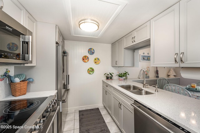 kitchen featuring white cabinetry, stainless steel appliances, sink, and light tile patterned floors