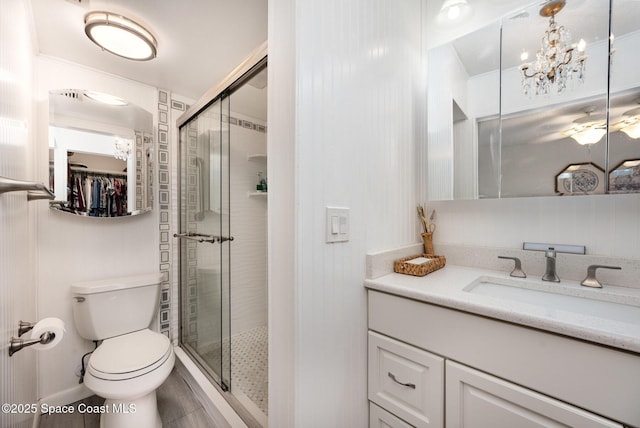 bathroom featuring walk in shower, vanity, toilet, and an inviting chandelier