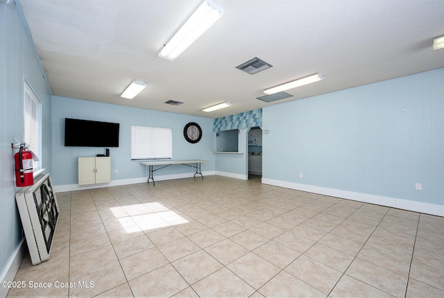 basement with light tile patterned floors and a textured ceiling