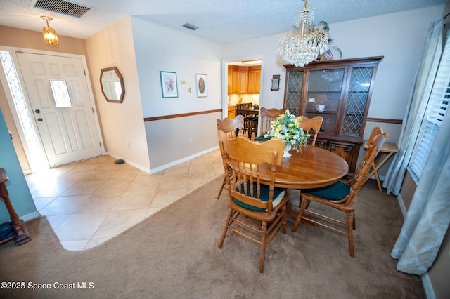 dining area with light tile patterned floors, a chandelier, and a textured ceiling