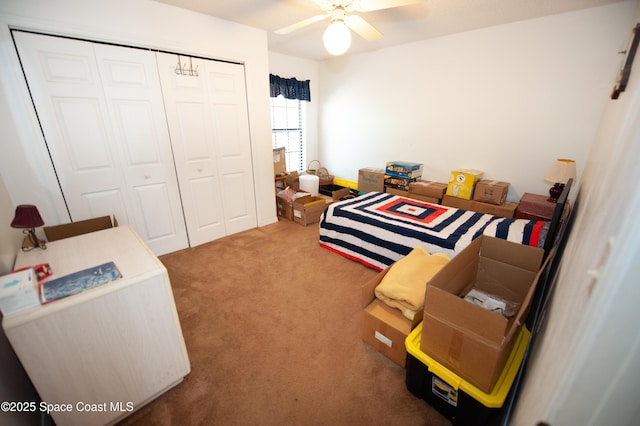 carpeted bedroom featuring ceiling fan and a closet