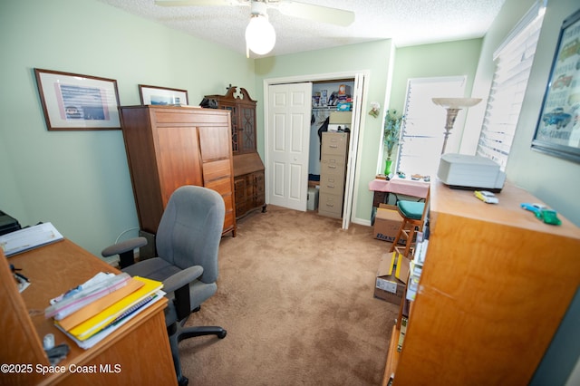 carpeted office with a textured ceiling and ceiling fan