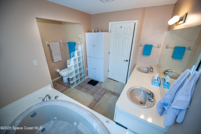 bathroom with toilet, a bath, tile patterned flooring, a textured ceiling, and vanity