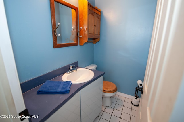 bathroom with toilet, tile patterned floors, and vanity