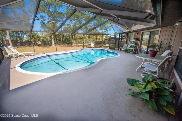 view of pool with a patio area and glass enclosure