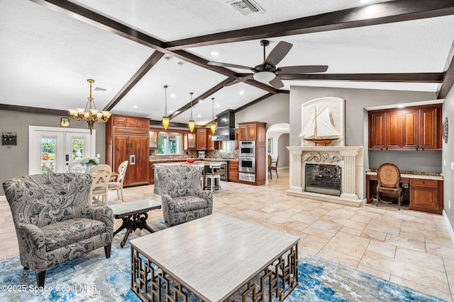 living room with ceiling fan, vaulted ceiling with beams, built in desk, a textured ceiling, and french doors