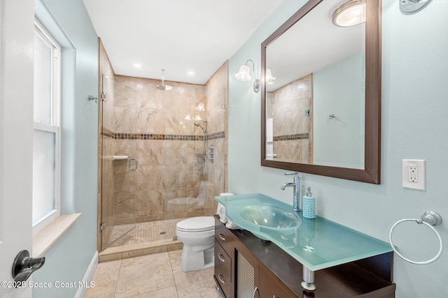 bathroom with a shower with door, vanity, tile patterned flooring, and toilet