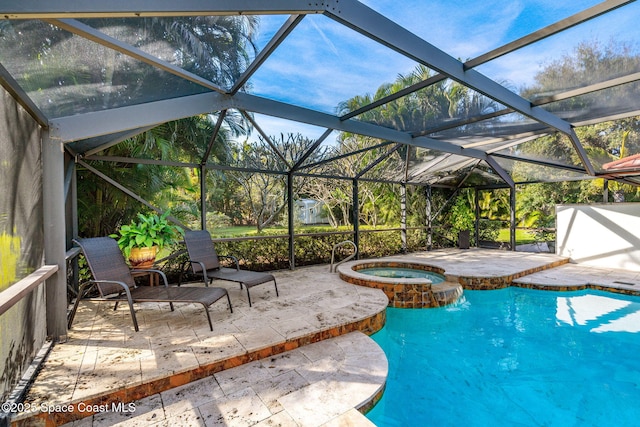 view of pool with a patio area, glass enclosure, and an in ground hot tub