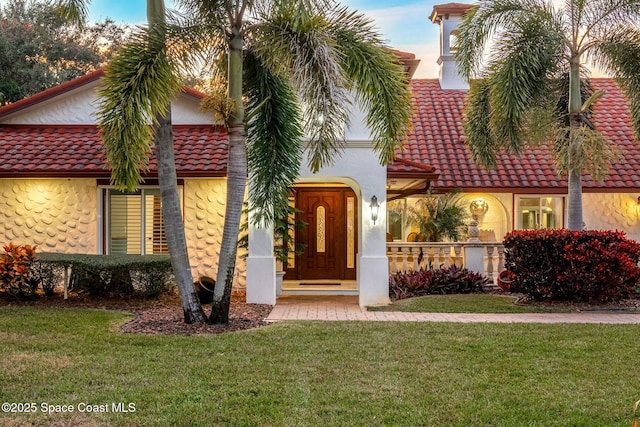 mediterranean / spanish-style home featuring a front yard