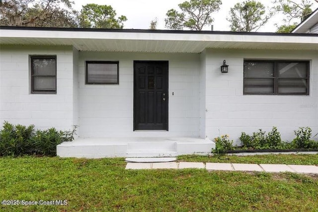 doorway to property with a lawn