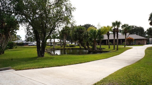 surrounding community with a yard and a water view