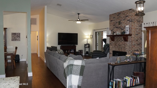 living room with ceiling fan, dark wood-type flooring, and a fireplace