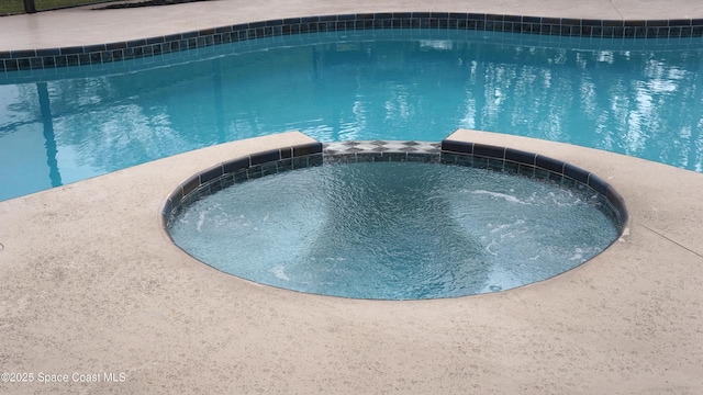 view of swimming pool featuring an in ground hot tub