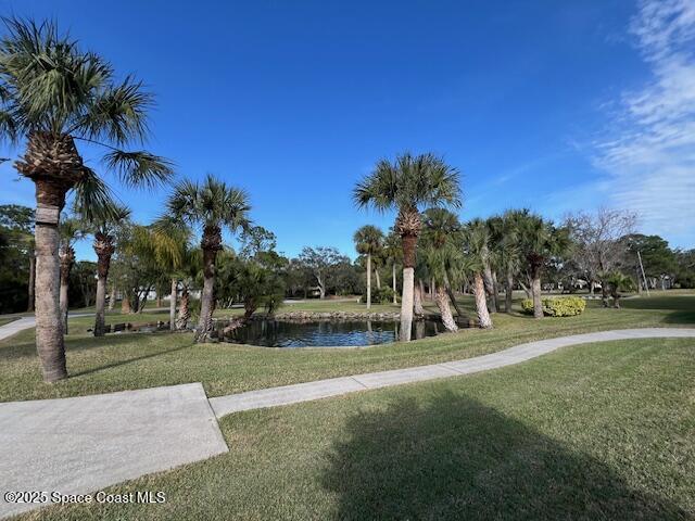 view of community featuring a water view and a yard