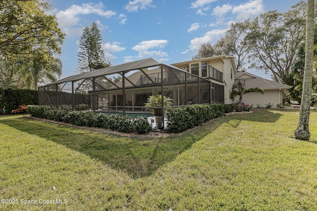 rear view of property featuring a lanai, a lawn, and a balcony