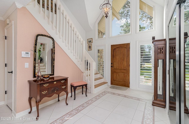 tiled foyer with a towering ceiling, plenty of natural light, and a notable chandelier