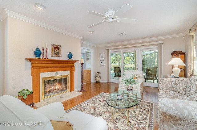 living room with ceiling fan, crown molding, and hardwood / wood-style flooring